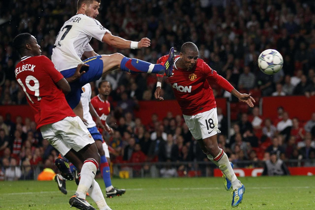 \'Manchester United\'s Ashley Young (R) heads to score against FC Basel during their Champions League Group C soccer match at Old Trafford in Manchester September 27, 2011. REUTERS/Eddie Keogh (BRITAI