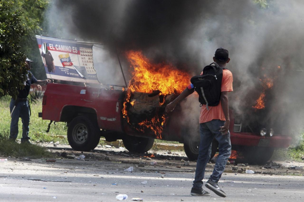 'A campaign truck is seen burning after rival supporters of Venezuelan President Hugo Chavez and opposition candidate Henrique Capriles clash in Puerto Cabello September 12, 2012. Rival supporters in 
