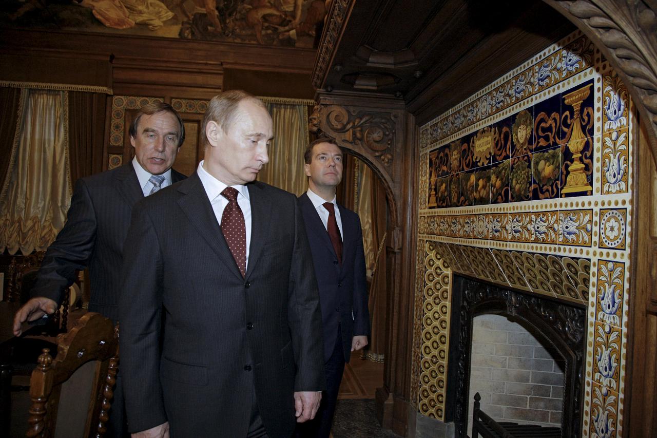 Russia's then President Dmitry Medvedev (R) and then Prime Minister Vladimir Putin (front) listen to Sergei Roldugin, art director of St. Petersburg House of Music, during an excursion around the house in St. Petersburg, Russia, in this picture taken Nove