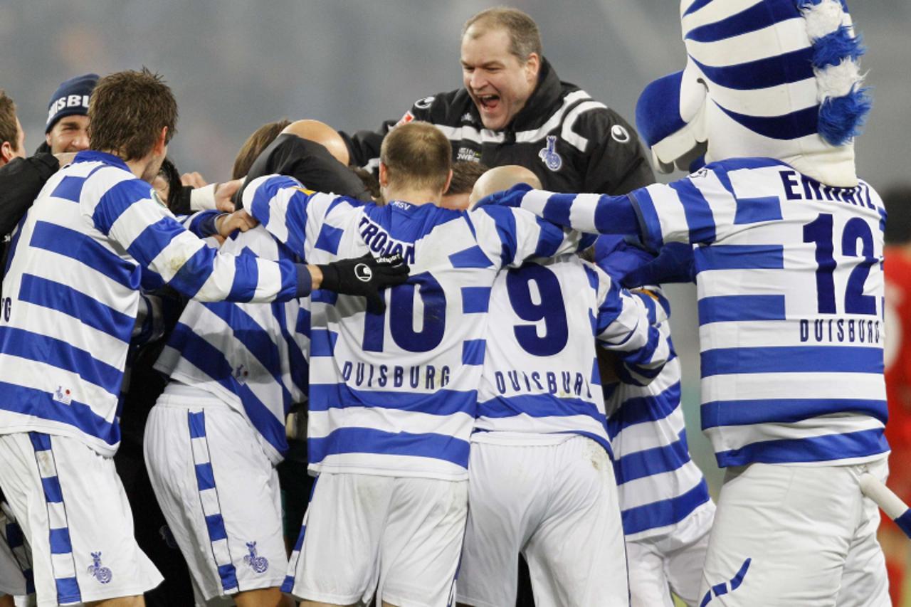 'MSV Duisburg coach Milan Sasic (R) jumps on his players to celebrate his team\'s victory over FC Energie Cottbus in their German soccer cup DFB Pokal semi-final soccer match in the western German cit