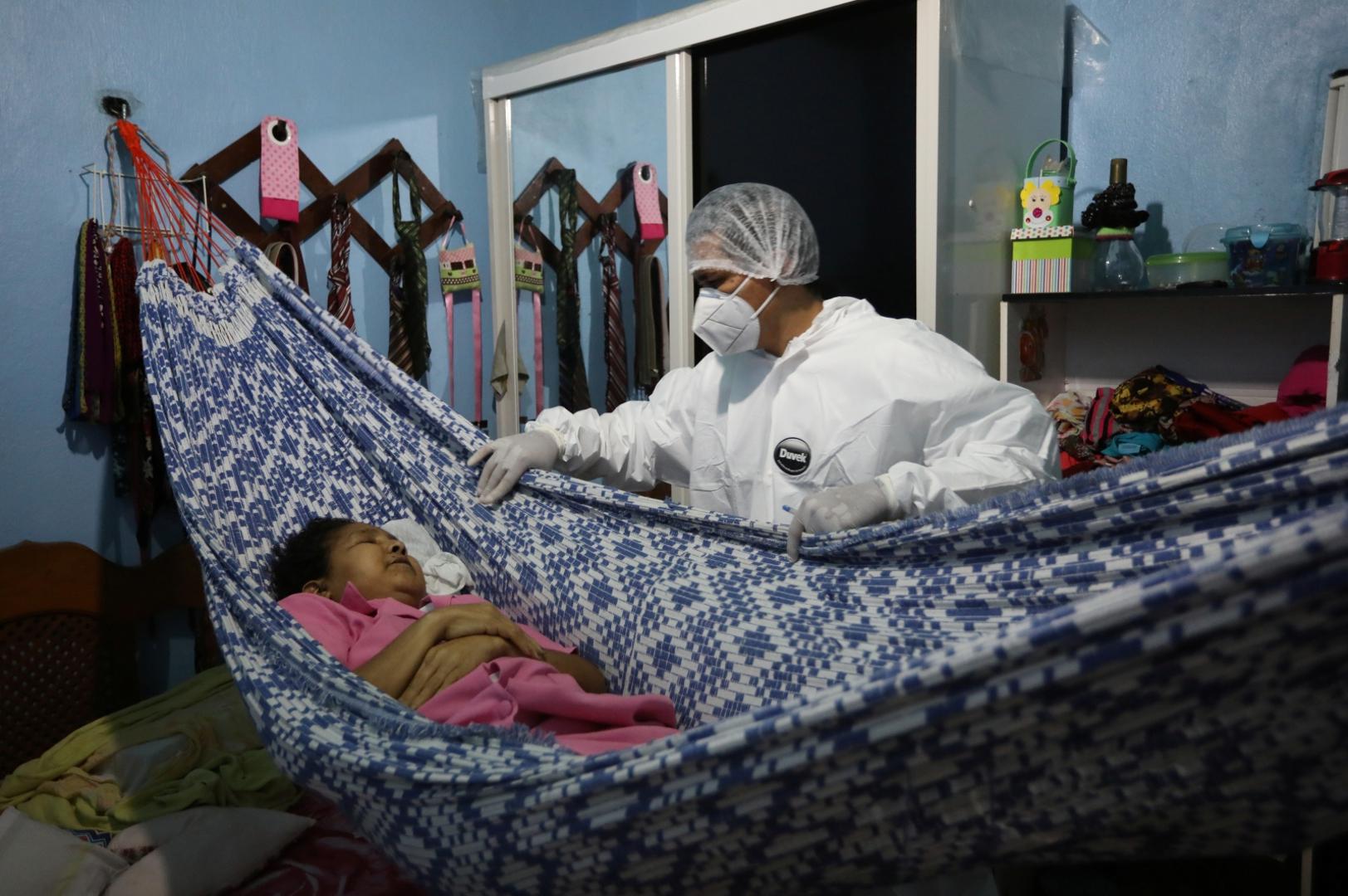 Outbreak of the coronavirus disease (COVID-19), in Manaus SENSITIVE MATERIAL. THIS IMAGE MAY OFFEND OR DISTURB A worker of the SOS Funeral, wearing protective clothing, prepares to remove the body of a woman who died from the coronavirus disease (COVID-19), from her house, in Manaus, Brazil, May 29, 2020. REUTERS/Bruno Kelly BRUNO KELLY