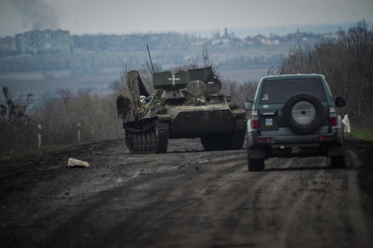 Ukrainian service members ride military vehicles