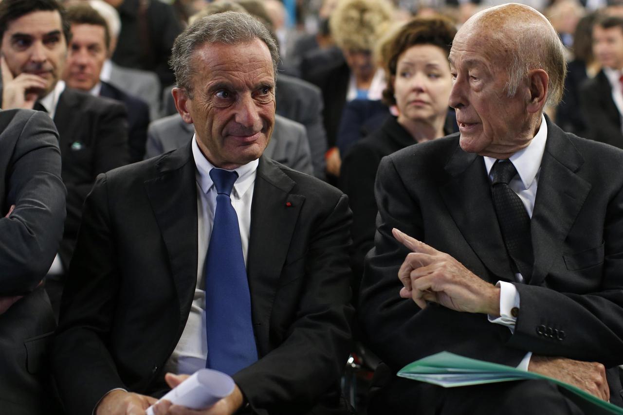 Henri Proglio (L), Chief Executive Officer of France's state-owned electricity company EDF, speaks with former French President Valery Giscard d'Estaing during the World Nuclear Exhibition 2014  (WNE), the trade fair event for the global nuclear energy se
