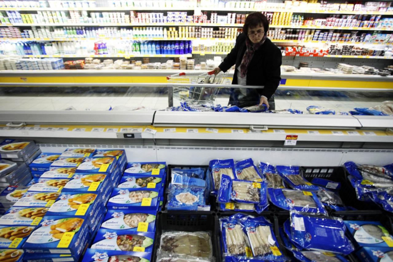'A woman browses frozen fish fillets, priced between 5 BAM ($3.35) and 10 BAM ($6.70), at a FIS supermarket in Vitez March 13, 2012. REUTERS/Dado Ruvic (BOSNIA AND HERZEGOVINA - Tags: BUSINESS FOOD SO