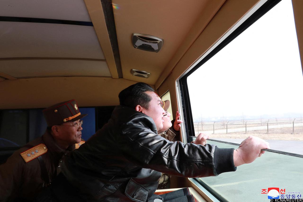 North Korean leader Kim Jong Un looks through a window during the test firing of what state media report is a "new type" of intercontinental ballistic missile (ICBM)
