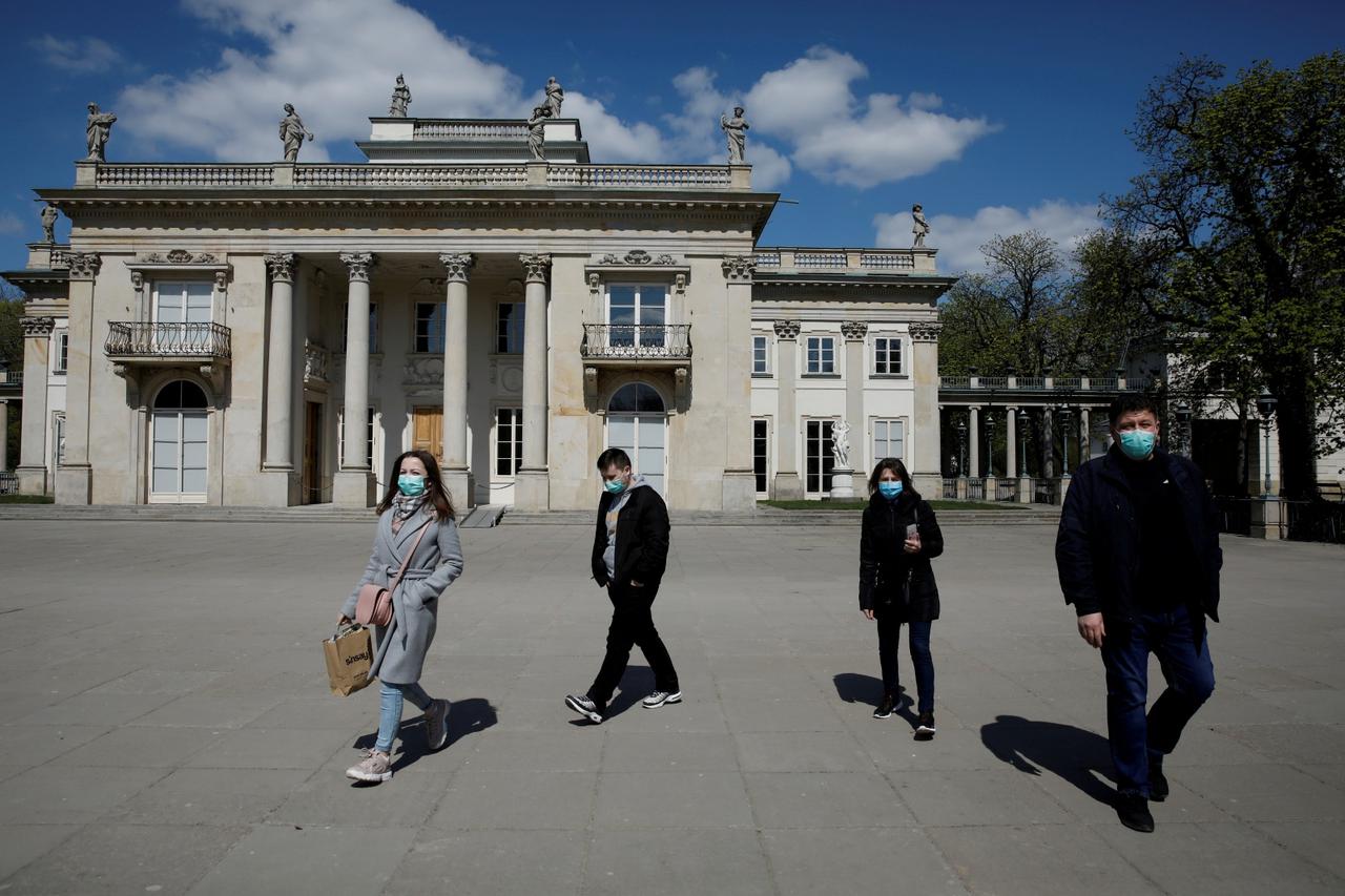 FILE PHOTO: People wearing protective masks enjoy walking in the Lazienki Royal Park after loosening of the lockdown measures by the government due to the coronavirus disease (COVID-19) in Warsaw