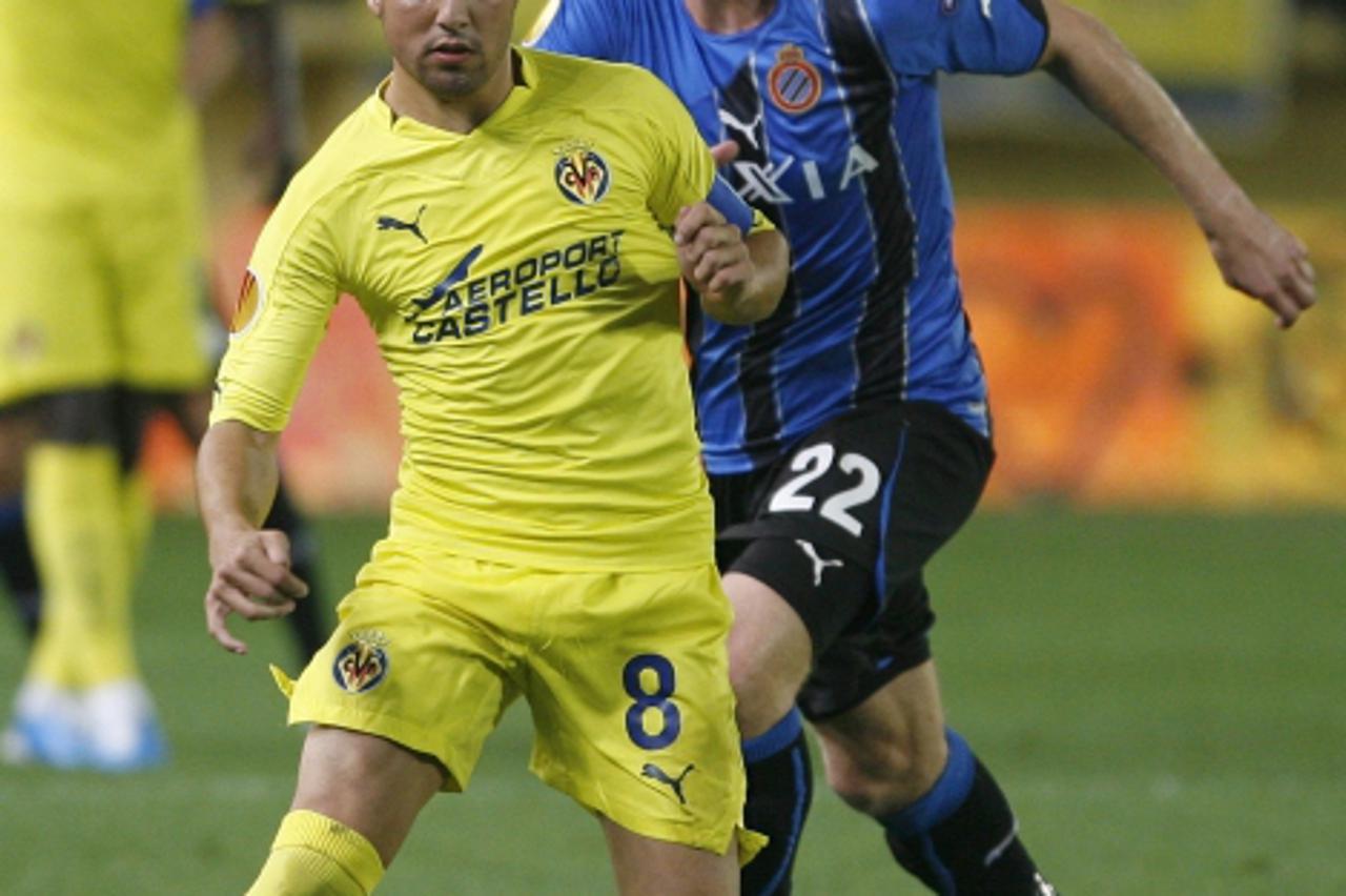 'Villarreal\'s Santiago Cazorla (front) controls the ball past Club Brugge\'s Karel Geraerts during their Europa League Group D soccer match at the Madrigal Stadium in Villarreal, September 30, 2010. 
