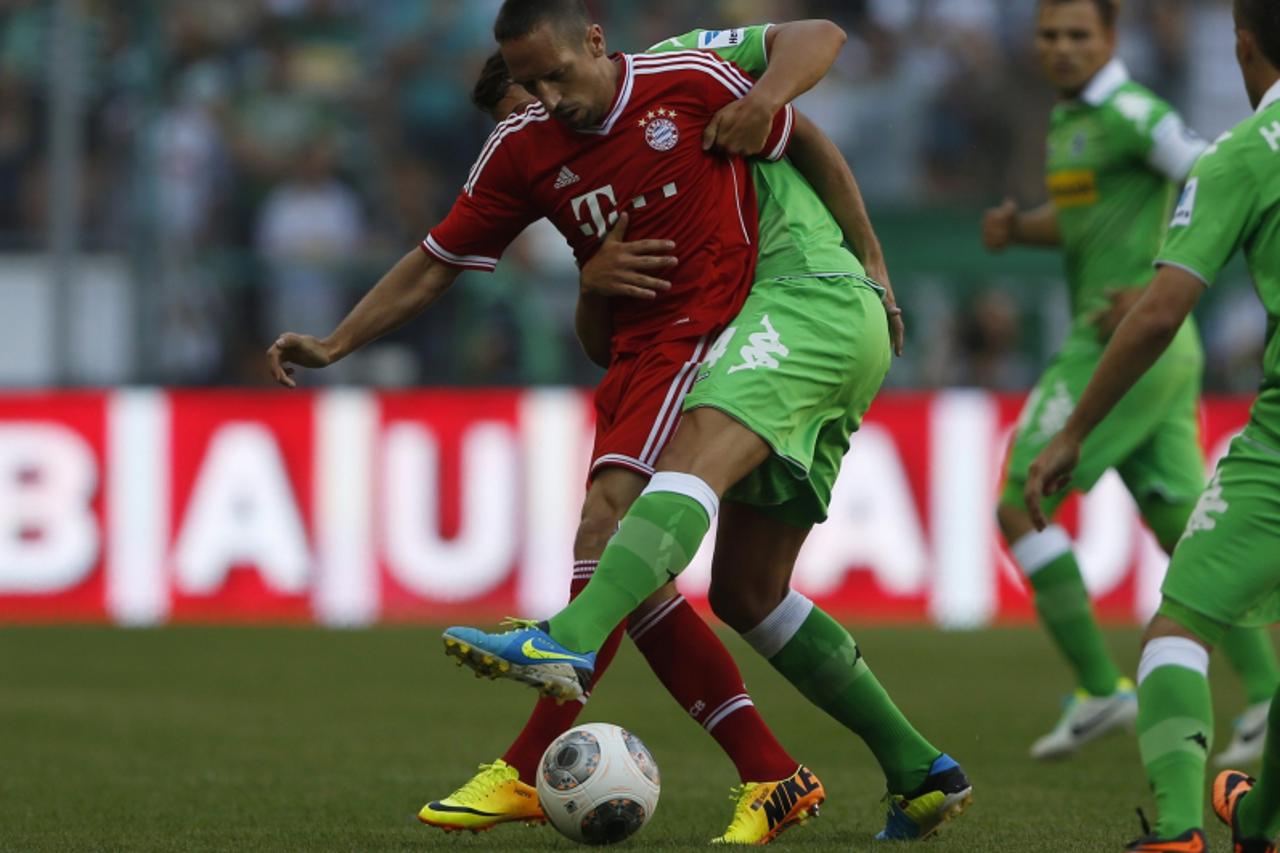 'Bayern Munich\'s Franck Ribery (red) is tackled by Borussia Moenchengladbach\'s Oscar Wendt during their Telekom Cup soccer match in Moenchengladbach July 21, 2013. REUTERS/Wolfgang Rattay (GERMANY -