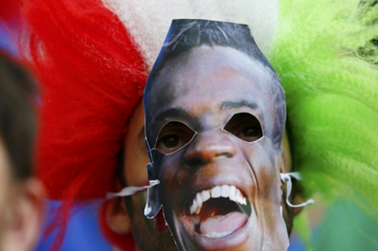 'Italian supporter wearing Mario Balotelli\'s face mask cheers before the game against Spain at their Group C Euro 2012 soccer match in Gdansk, June 10, 2012.     REUTERS/Kai Pfaffenbach (POLAND  - Ta