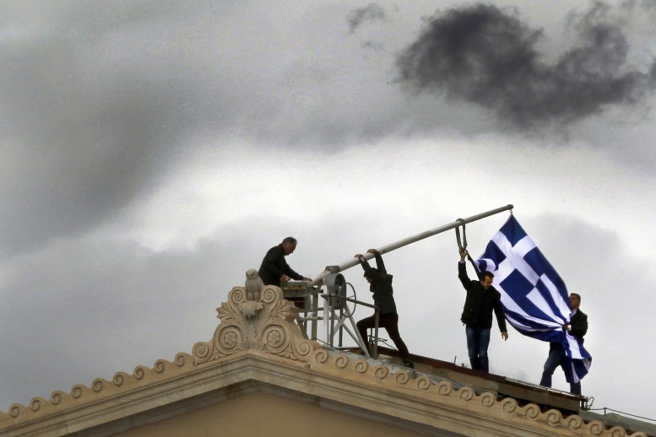 'Parliament employees raise a mast after they replaced a torn-off Greek flag with a new one atop the parliament in Athens Syntagma (Constitution) square April 18, 2012. Greeks go to the polls in about