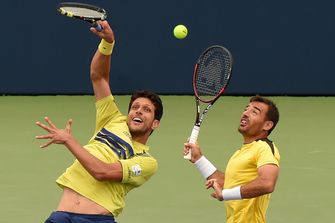 Jul 31, 2016; Toronto, Ontario, Canada;  Marcelo Melo of Brazil hits a shot beside partner Ivan Dodig of Croatia in the men's doubles final against Jamie Murray of Britain and Bruno Soares of Brazi (not pictured)l on day seven of the Rogers Cup tennis tou