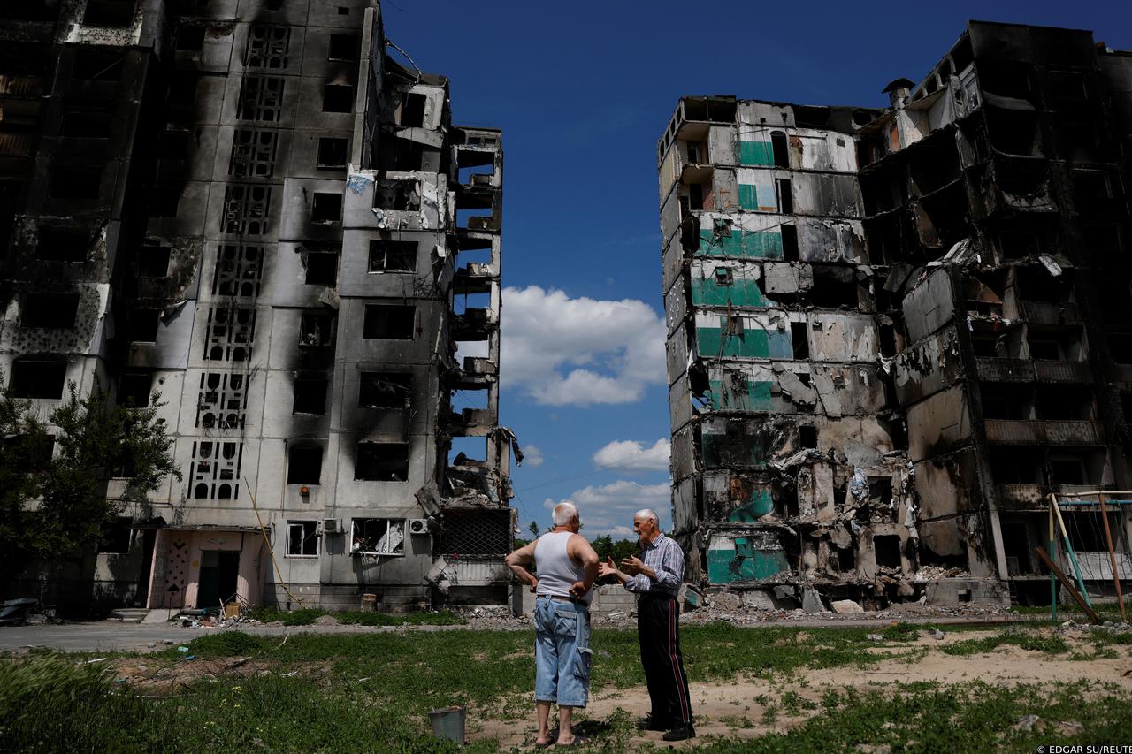 Residents chat in front of a destroyed building in Borodianka