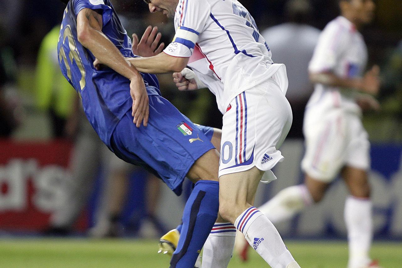 Italy's Marco Materazzi falls on the pitch after being head-butted by France's Zinedine Zidane (R) during their World Cup 2006 final soccer match in Berlin July 9, 2006. FIFA RESTRICTION - NO MOBILE USE HOLLAND OUT  Picture taken July 9, 2006. REUTERS/Pet