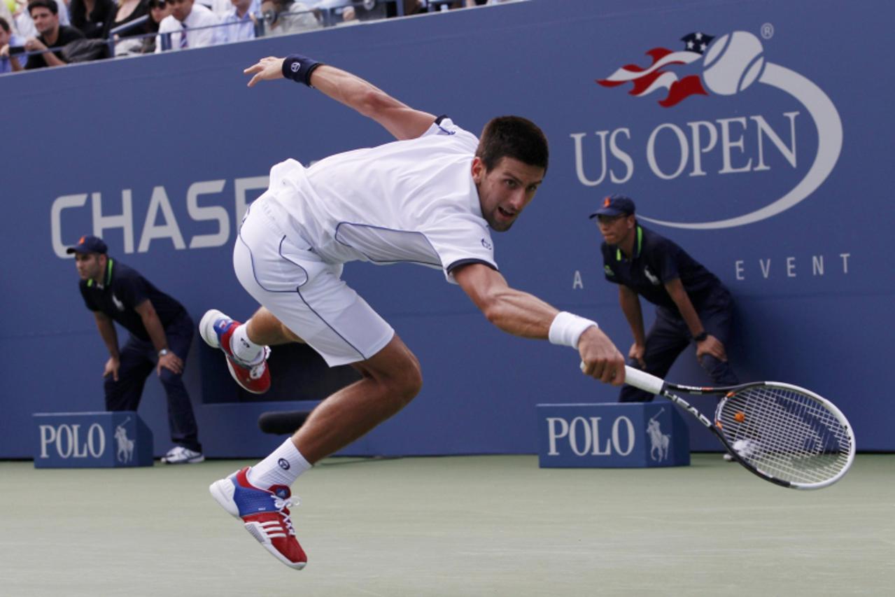 \'Novak Djokovic of Serbia lunges to make a return to compatriot Janko Tipsarevic during their match at the U.S. Open tennis tournament in New York, September 8, 2011.      REUTERS/Mike Segar (UNITED 