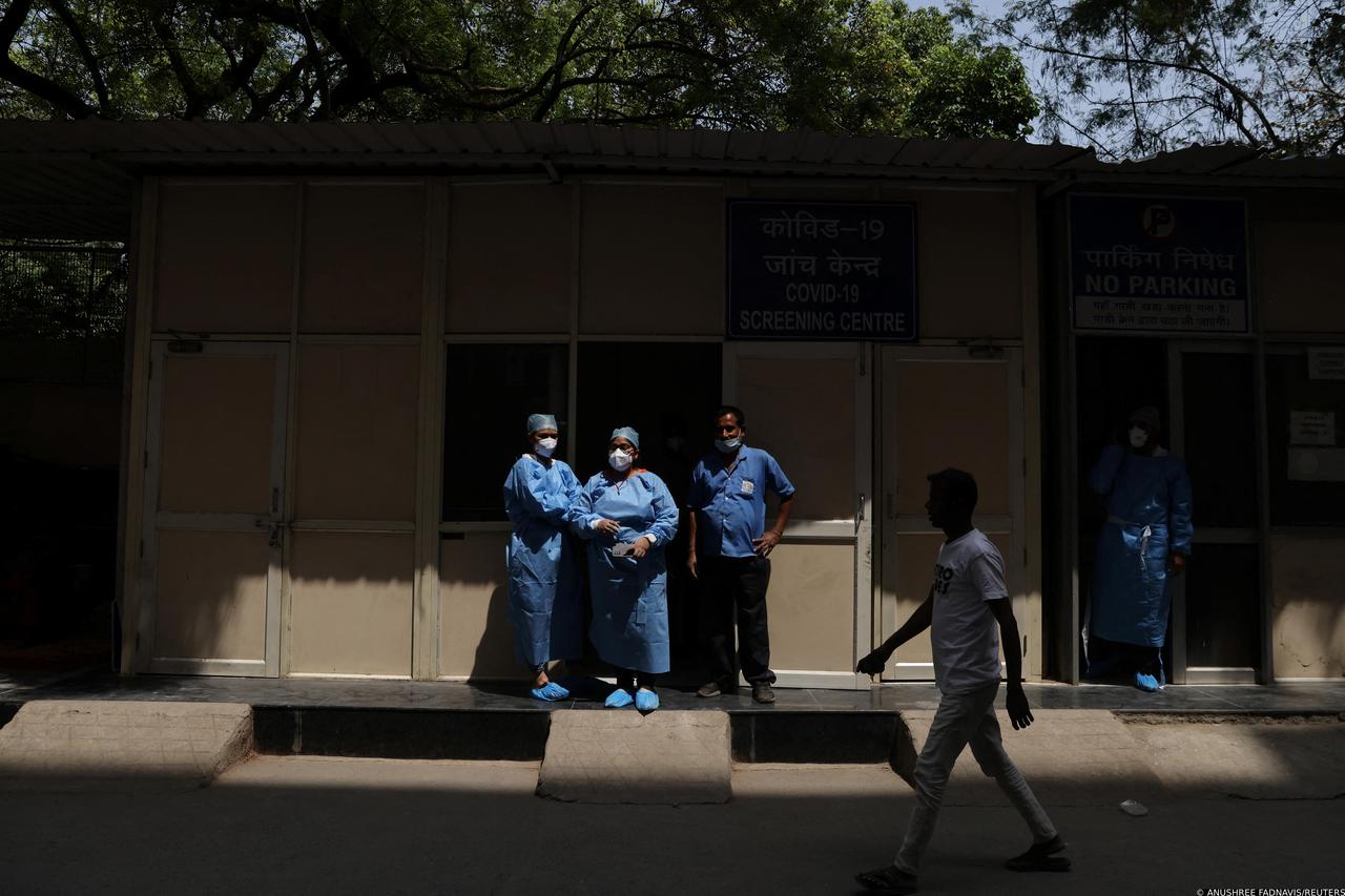 Healthcare workers stand outside a testing centre in a hospital, in New Delhi