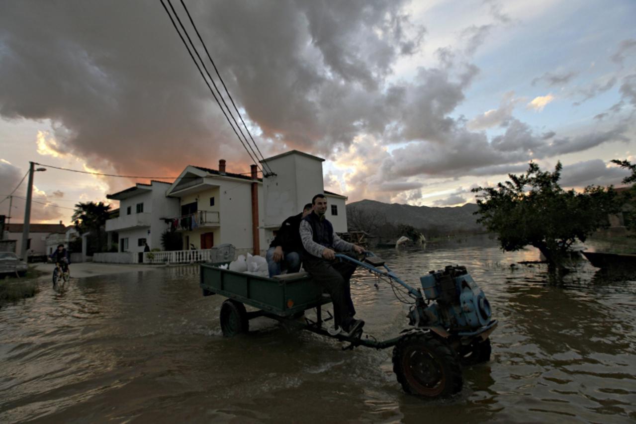 \'Villagers drive their small tractor through a neighborhood flooded by water from the Neretva river in Croatia\'s town of Metkovic some 550 kilometers south of capital Zagreb December 2, 2010. Heavy 