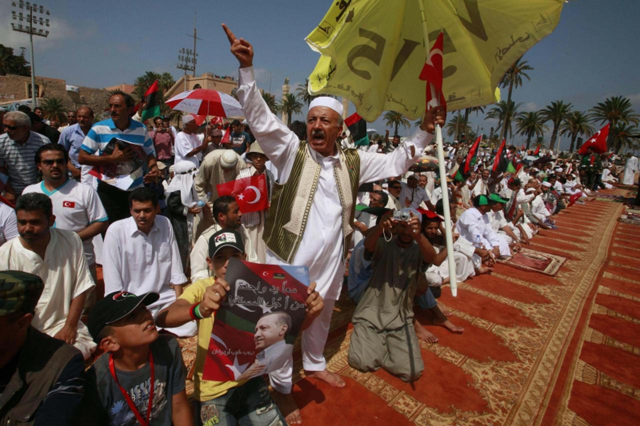 \'Libyans celebrate the arrival of Turkey\'s Prime Minister Tayyip Erdogan at Martyrs\' Square to attend Friday prayers in Tripoli September 16, 2011.  REUTERS/Suhaib Salem (LIBYA - Tags: POLITICS CIV
