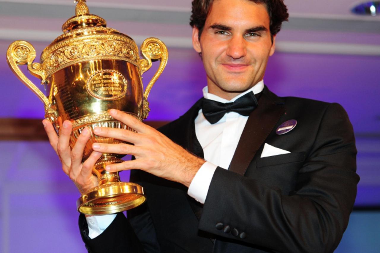 'Switzerland\'s Roger Federer with the Men\'s Singles Trophy during the Champions Ball at the Intercontinental Hotel, London. Photo: Press Association/Pixsell'