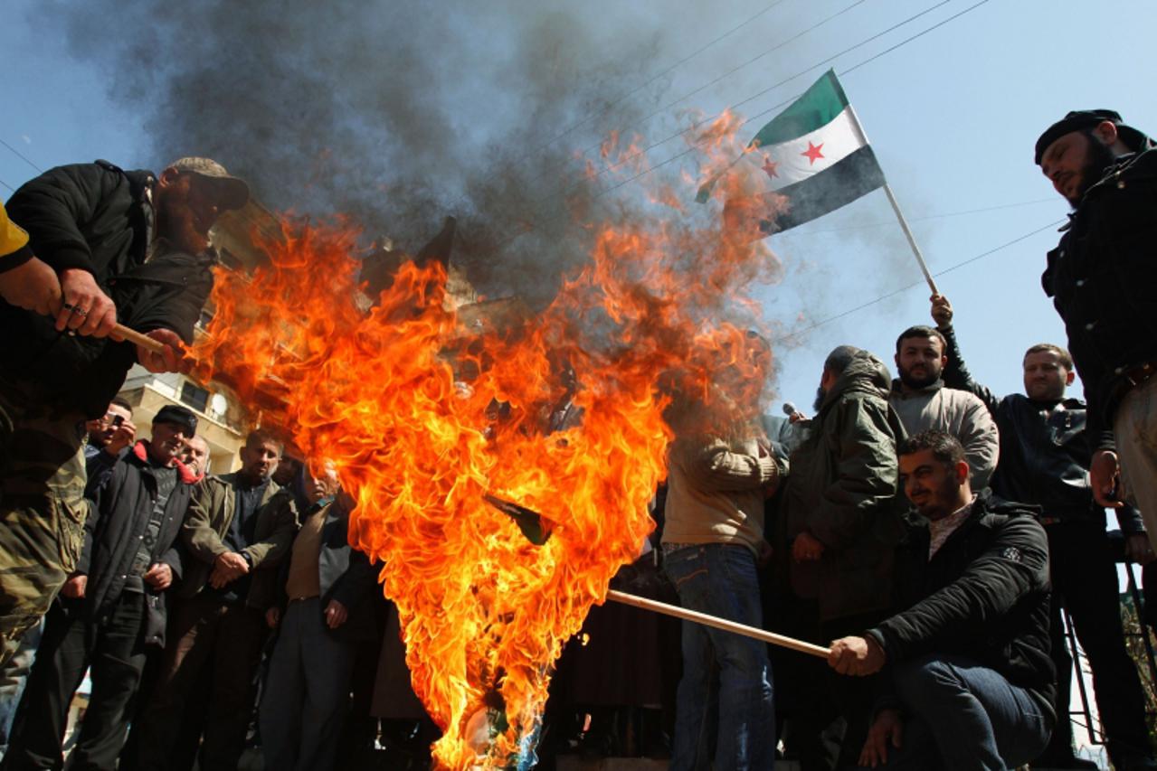 'Lebanese protesters burn Israeli and Iranian flags during a protest in solidarity with Syria\'s anti-government protesters, in Tripoli, northern Lebanon, March 30, 2012.       REUTERS/Omar Ibrahim   