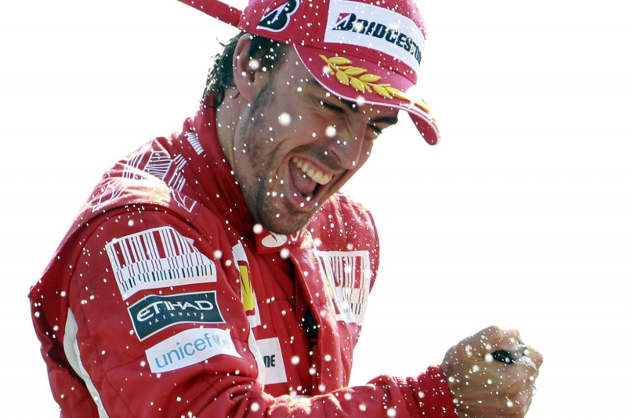 'Ferrari Formula One driver Fernando Alonso of Spain celebrates on the podium after winning the Italian F1 Grand Prix at the Monza circuit September 12, 2010. REUTERS/Stefano Rellandini          (ITAL