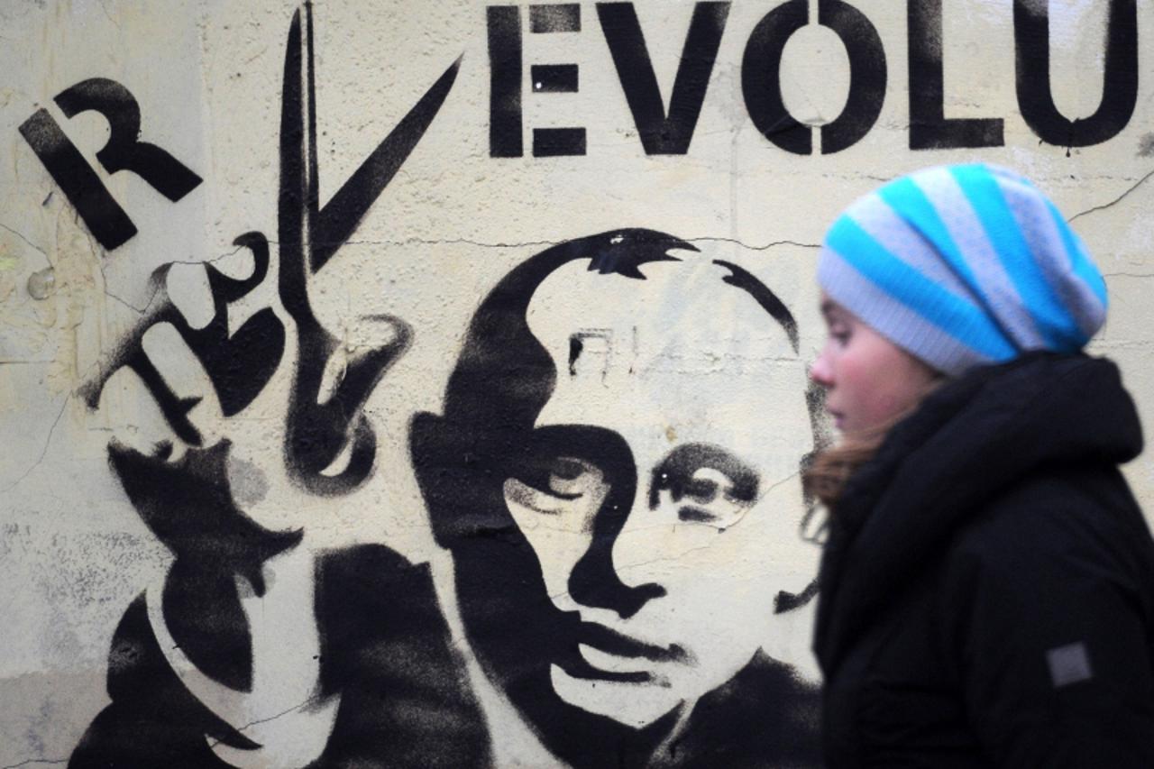 \'1062346 Russia, Moscow. 03/11/2012 A young woman walks past a graffiti depicting Vladimir Putin. Vladimir Astapkovich/RIA Novosti\'