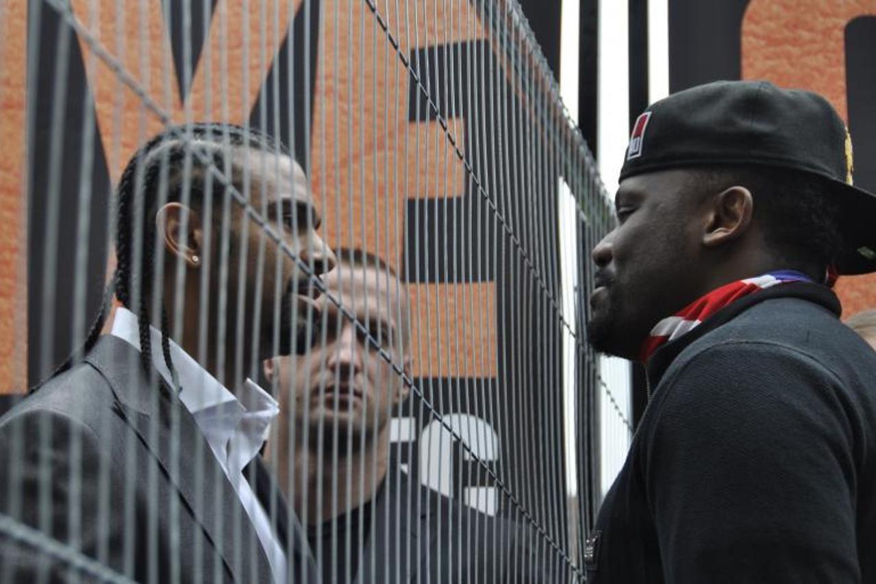 'Suspended professional boxer Dereck Chisora (R) stands next to a fence next to boxer David Haye (L) during a press conference at West Ham United\'s Boleyn Ground in London, England, 08 May 2012. Chis