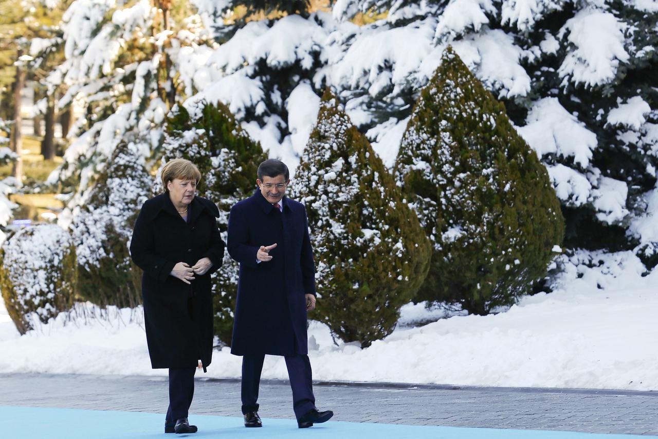 Turkish Prime Minister Ahmet Davutoglu (R) and German Chancellor Angela Merkel chat during a welcoming ceremony in Ankara, Turkey February 8, 2016.  REUTERS/Umit Bektas