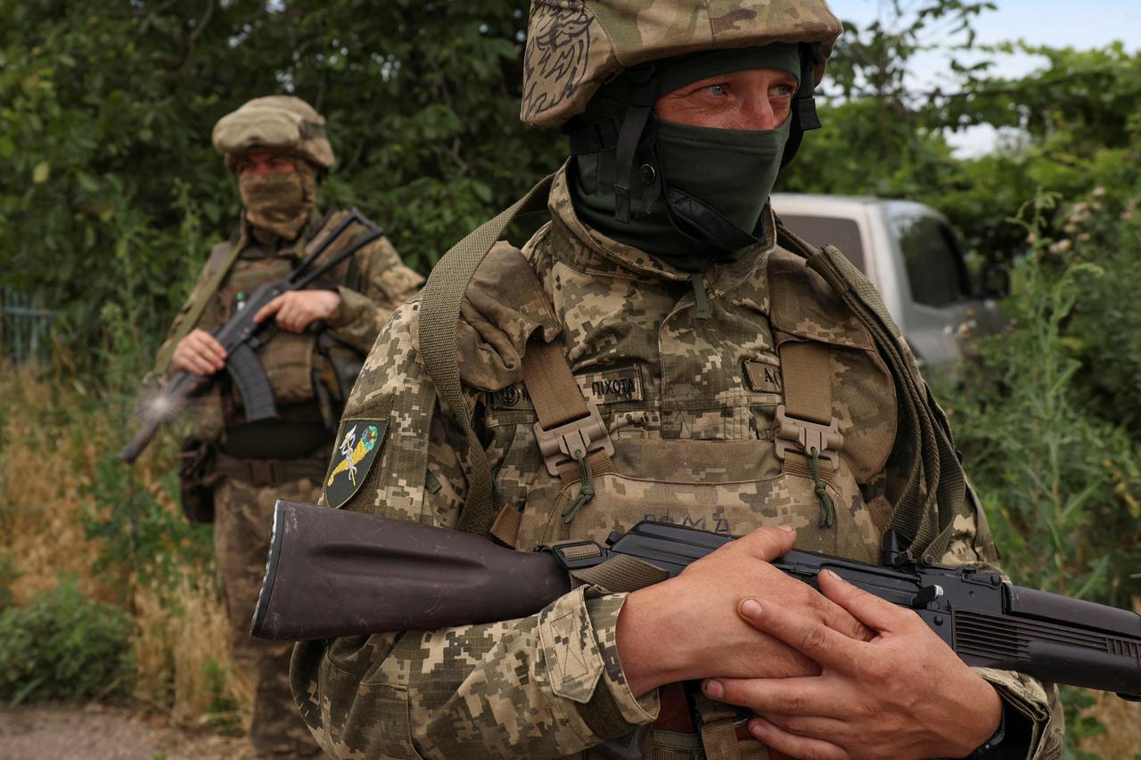 Ukrainian servicemen look on in the village of Vremivka