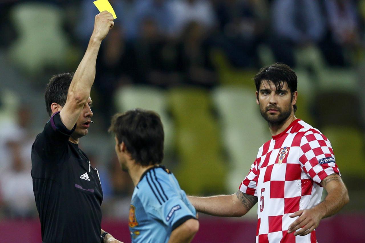 'Croatia\'s Vedran Corluka (R) reacts after receiving a yellow card by referee Wolfgang Stark of Germany during their Group C Euro 2012 soccer match against Spain at the PGE Arena in Gdansk June 18, 2