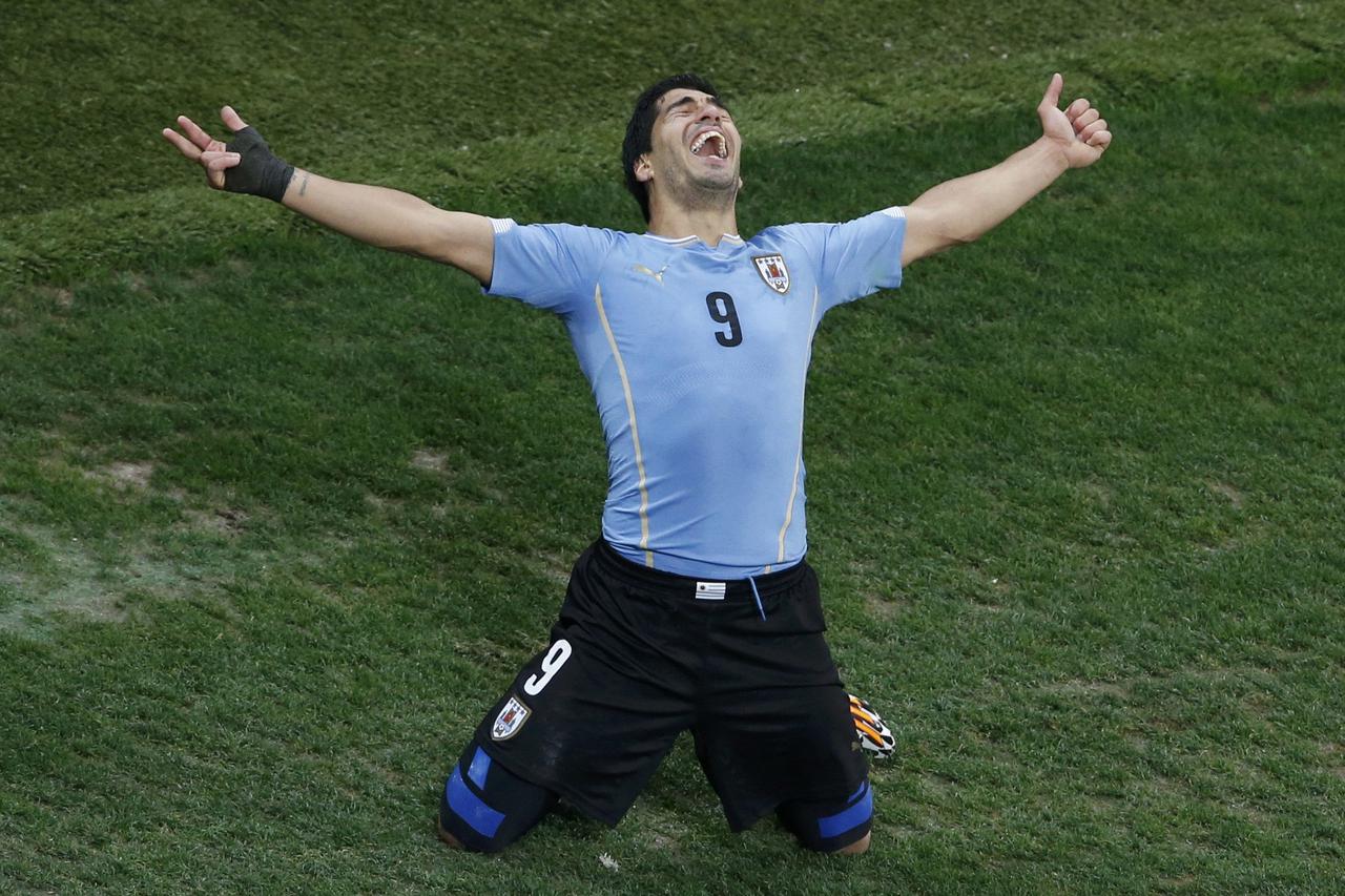 Uruguay's Luis Suarez celebrates scoring his team's second goal against England during their 2014 World Cup Group D soccer match at the Corinthians arena in Sao Paulo June 19, 2014.  REUTERS/Paulo Whitaker (BRAZIL  - Tags: SOCCER SPORT WORLD CUP TPX IMAGE