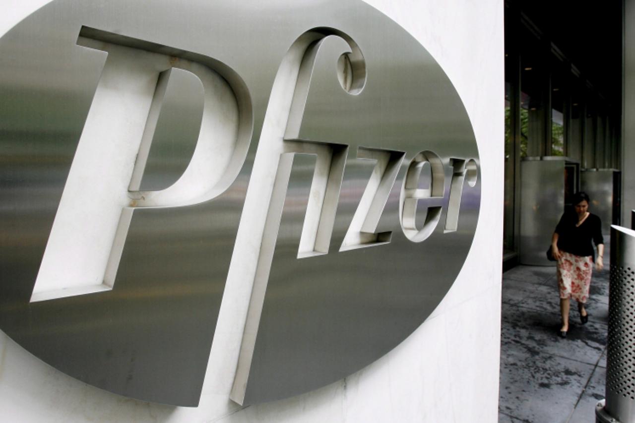 'epa01029346 (FILE) A file photograph showing a woman walking past a sign in front of the world headquarters building of Pfizer Inc. in New York on Monday 26 June 2006. It was reproted 05 June 2007 th
