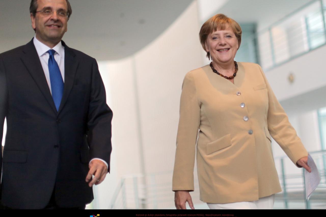 'German Chancellor Angela Merkel (R) and Greek Prime Minister Antonis Samaras walk to a press conference at the Chancellery in Berlin, Germany, 24 August 2012. The politicians meet to discuss further 