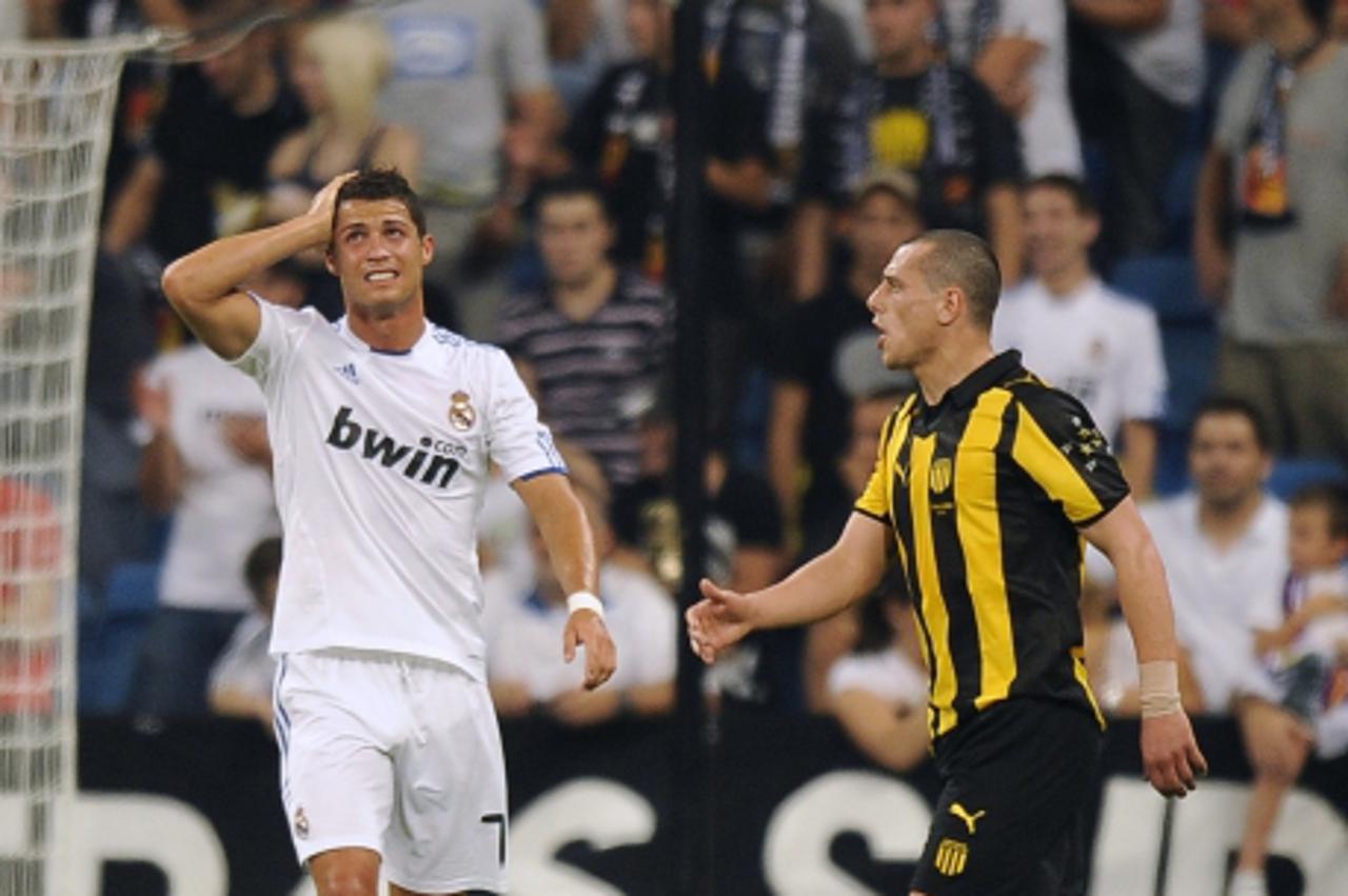'Real Madrid\'s Portuguese forward Cristiano Ronaldo (L) reacts during the Santiago Bernabeu trophy against Pen\\u0303arol at the Santiago Bernabeu Stadium, on August 24, 2010 in Madrid.    AFP PHOTO/