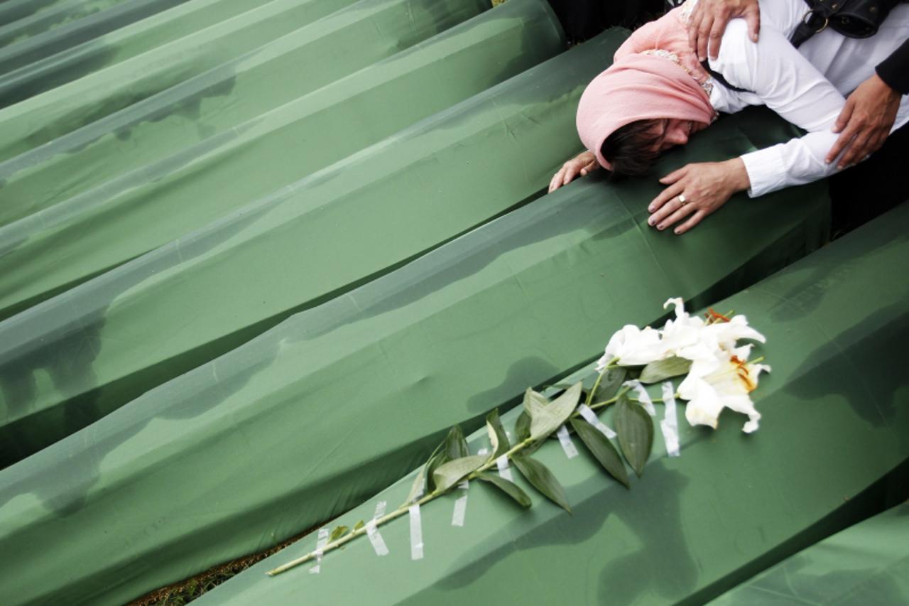 'A Bosnian woman cries on the coffin of a relative, which is one of the 409 coffins of newly identified victims from the 1995 Srebrenica massacre, in Potocari Memorial Center, near Srebrenica July 11,